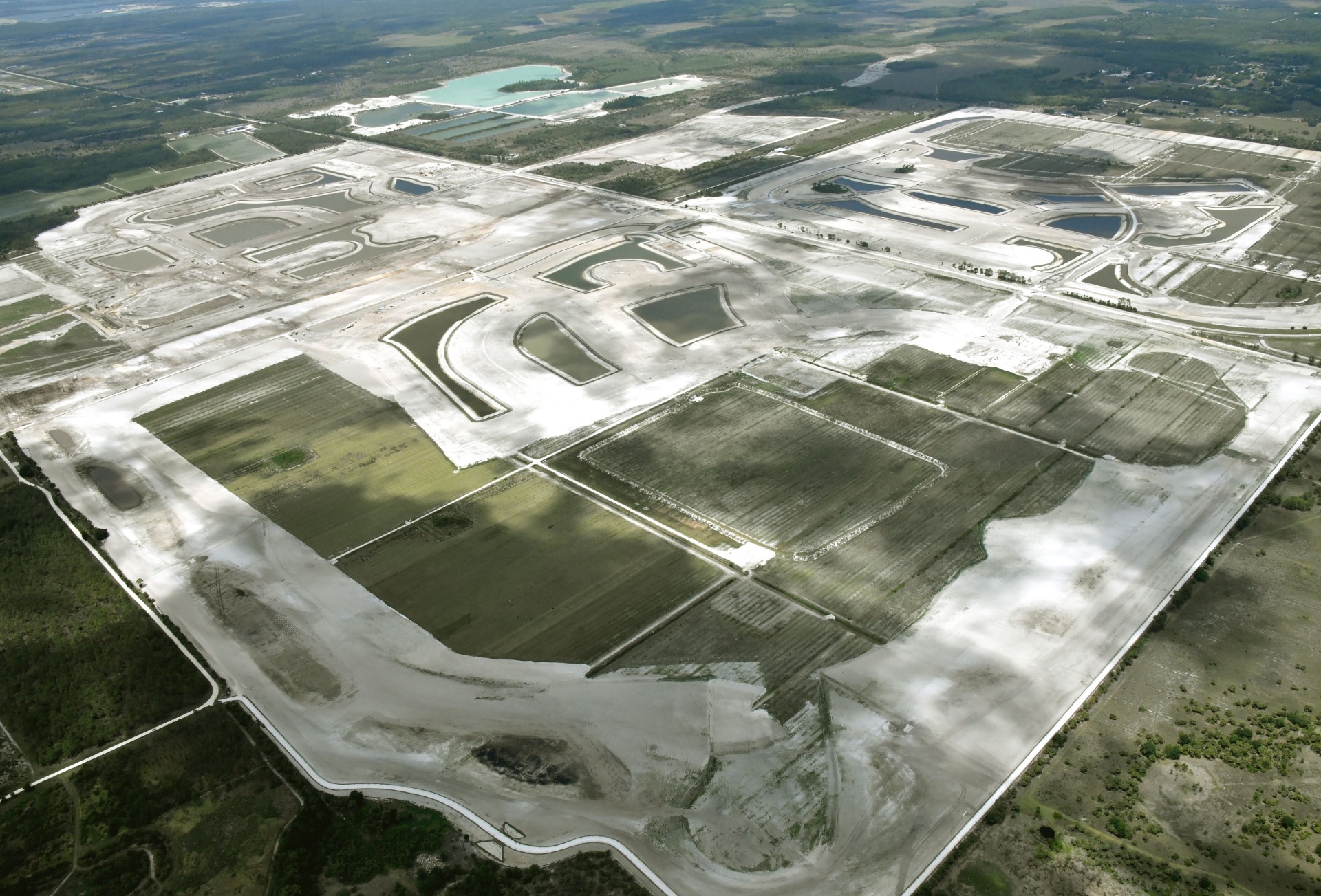 Aerial photo of the Kingston master plan site in Estero, Florida showing completed lake systems and pad-graded neighborhood parcels