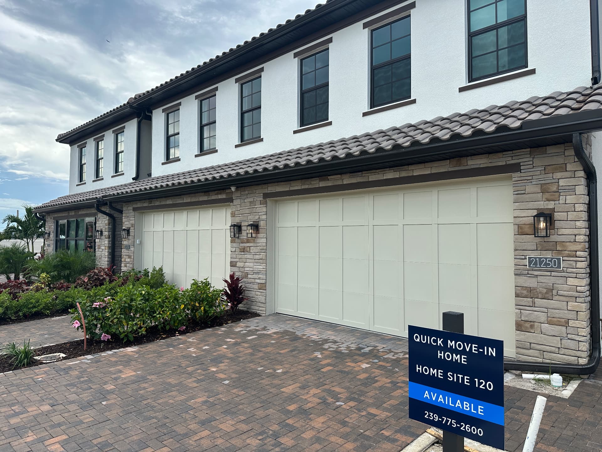 Quick move-in Summercrest townhome at home site 120 in Estero, Florida with paver driveway and stone accents, photographed September 6, 2026