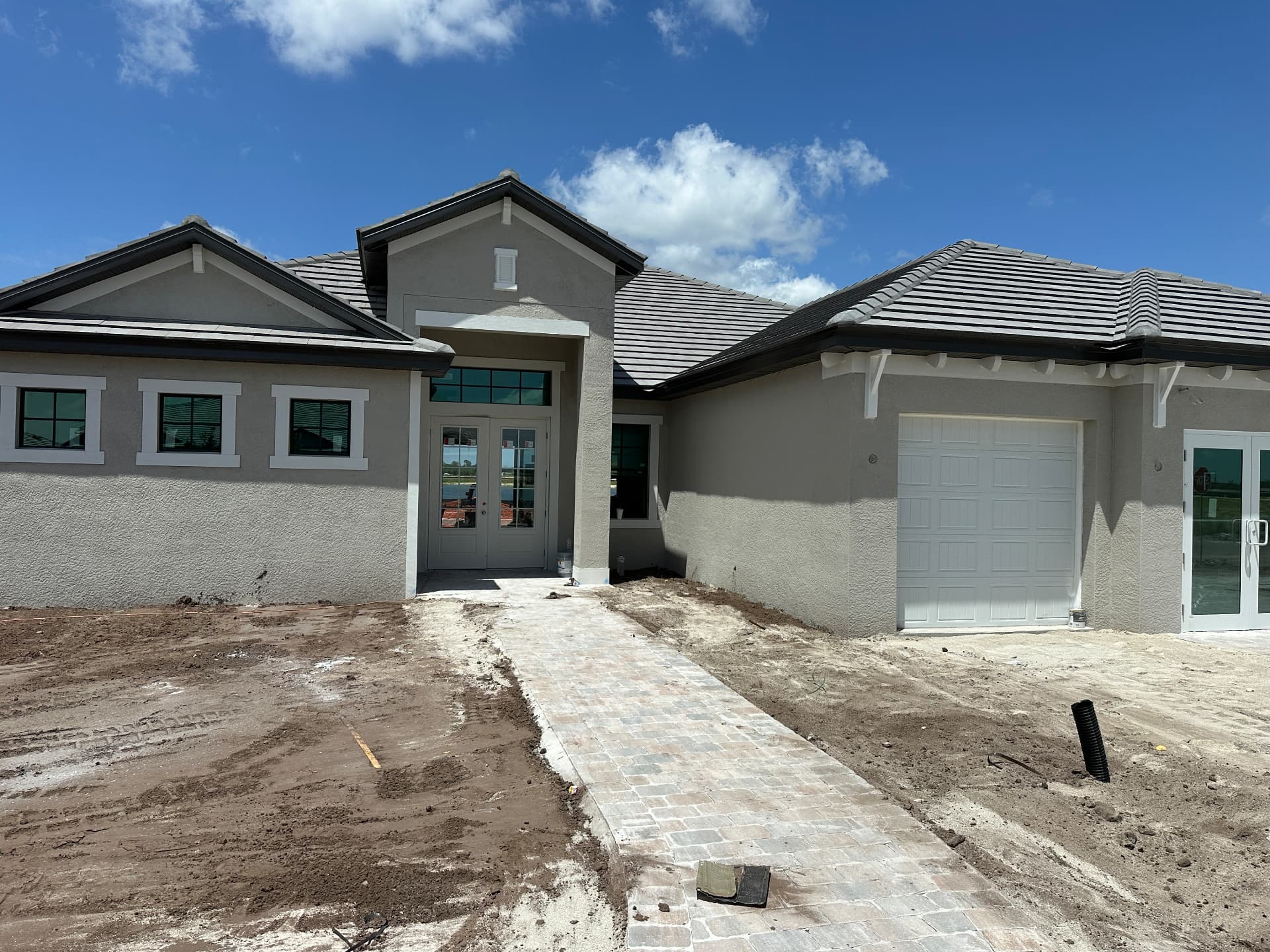 Estate-size new construction home with double-door front entry in Kingston, Estero, Florida — August 2026